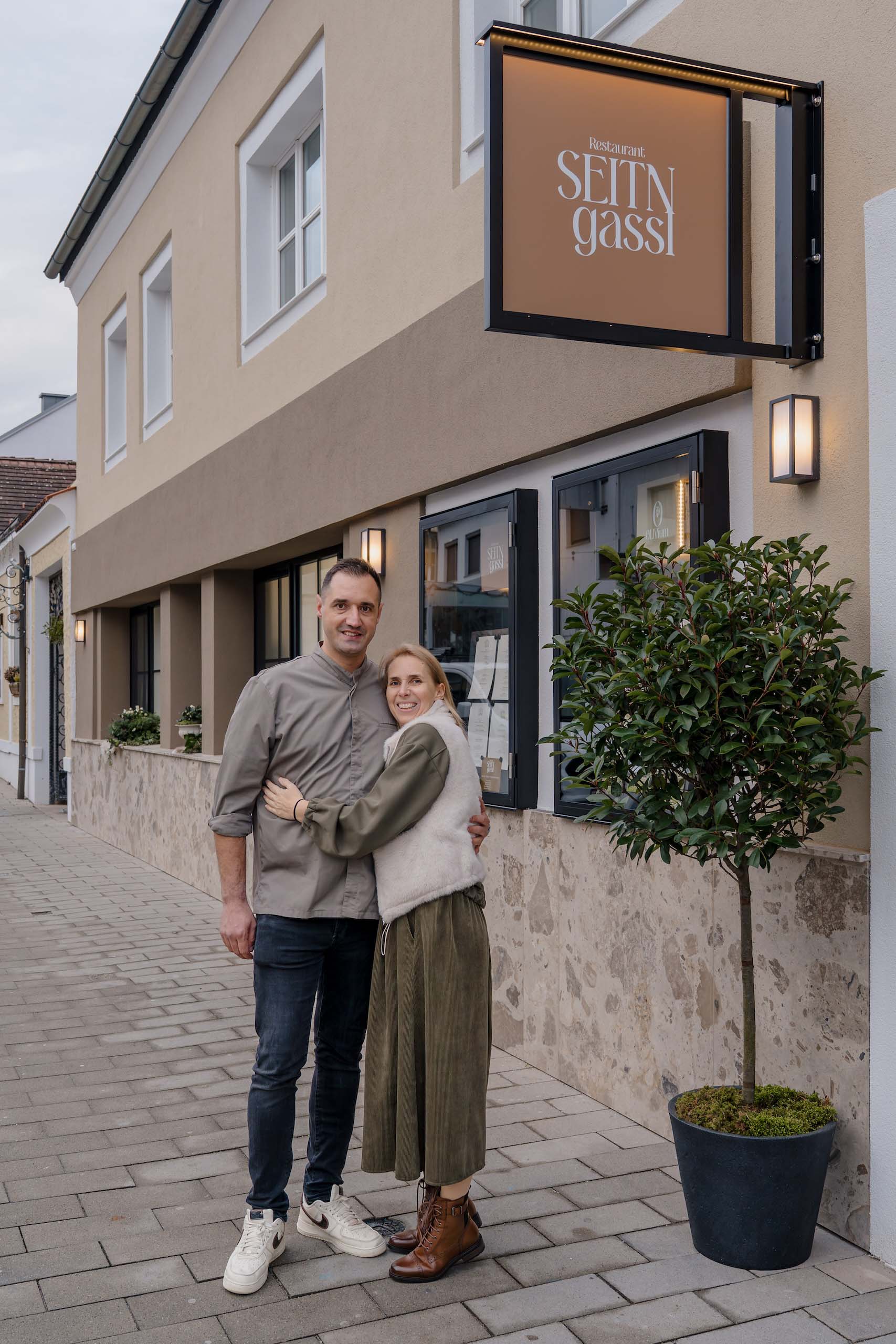 Paar vor Restaurant Seitngasse; potenzielle Hochzeitslocation für Ihren Traumtag. Entspannt und einladend für Ihre Feier.