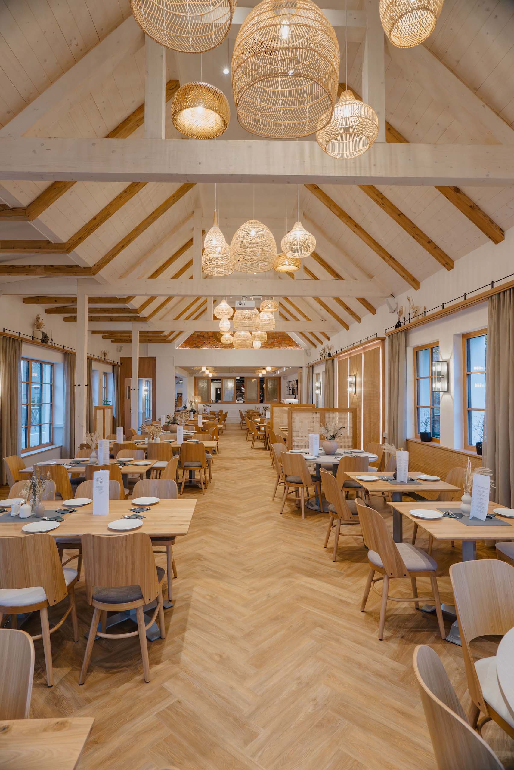 Stilvolle Hochzeitshalle mit Holztischen und warmem Licht, ideal für traumhafte Hochzeitsfeiern.