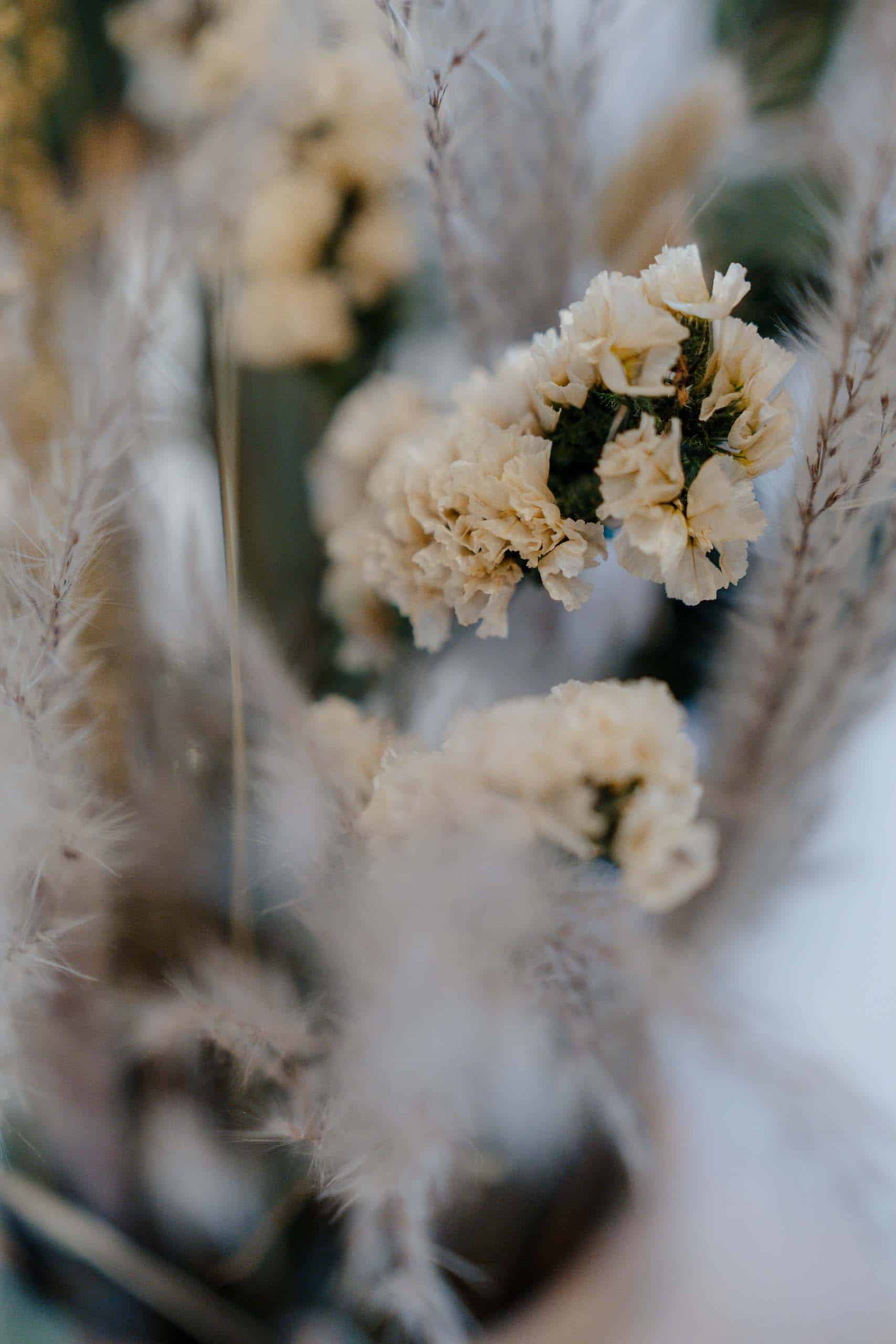Trockenblumenarrangement mit zarten Blüten und Gräsern, perfektes Detail für die Dekoration einer traumhaften Hochzeitslocation.