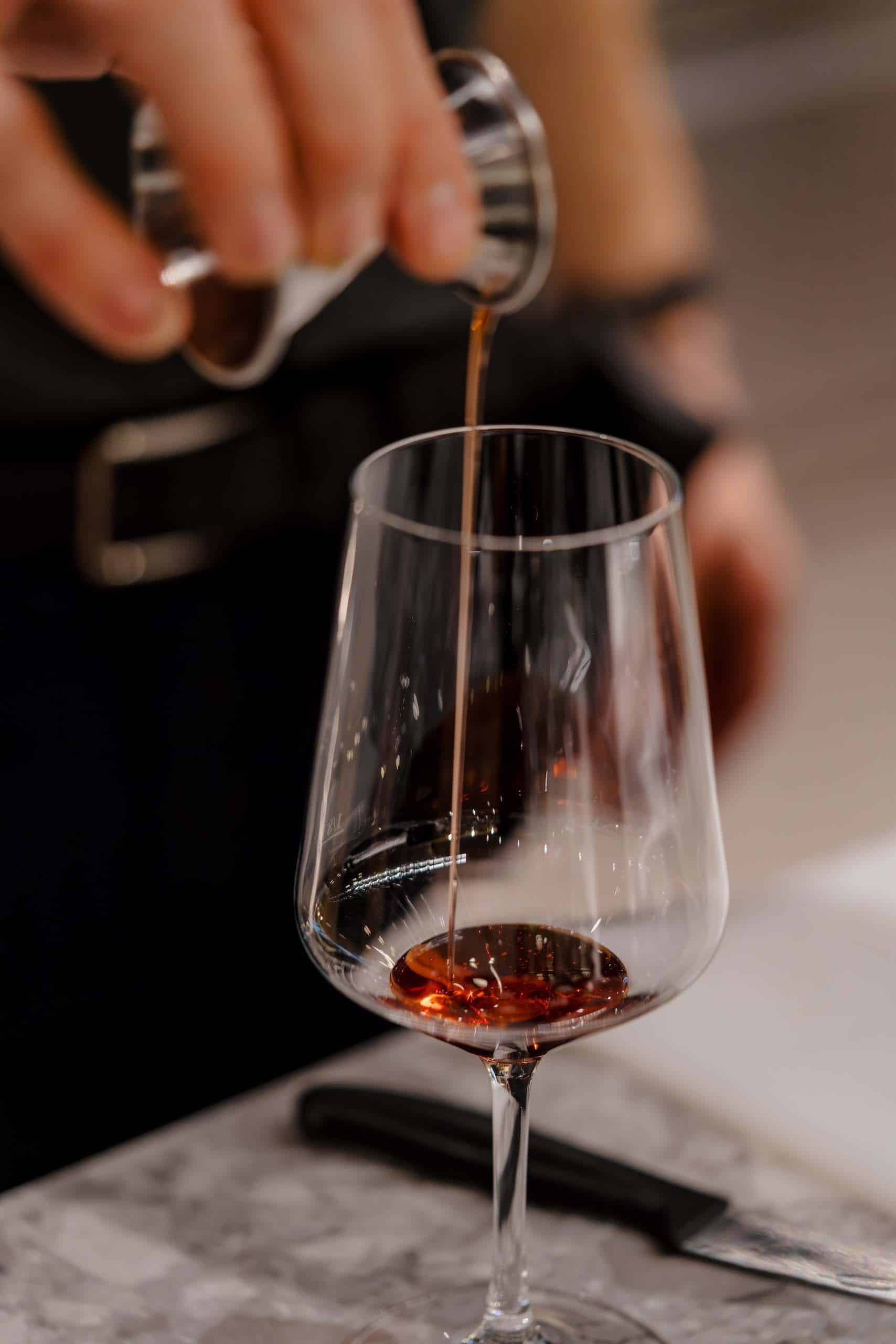 Ein Glas Wein wird elegant eingeschenkt, ideal für elegante Hochzeitslocations und unvergessliche Hochzeitsfeiern.