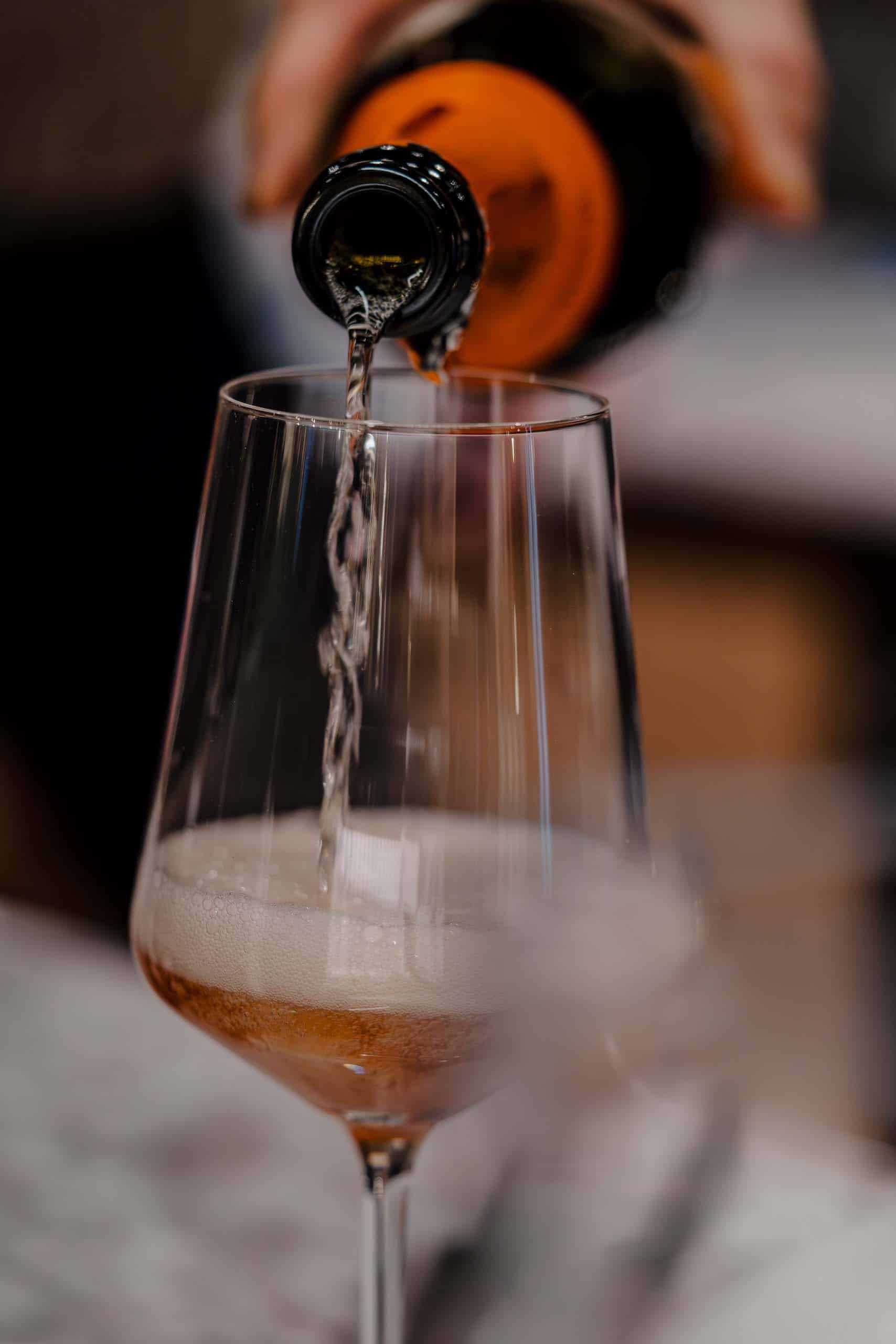 Champagner wird in ein Glas gegossen, ideal für einen Hochzeitstoast in einer eleganten Hochzeitslocation.