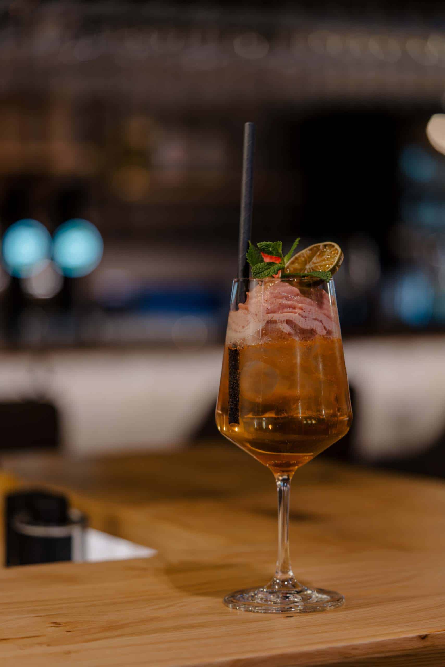 Erfrischender Cocktail mit Limette und Minze auf eleganter Hochzeitstafel, perfekte Hochzeitslocation-Ambiente.