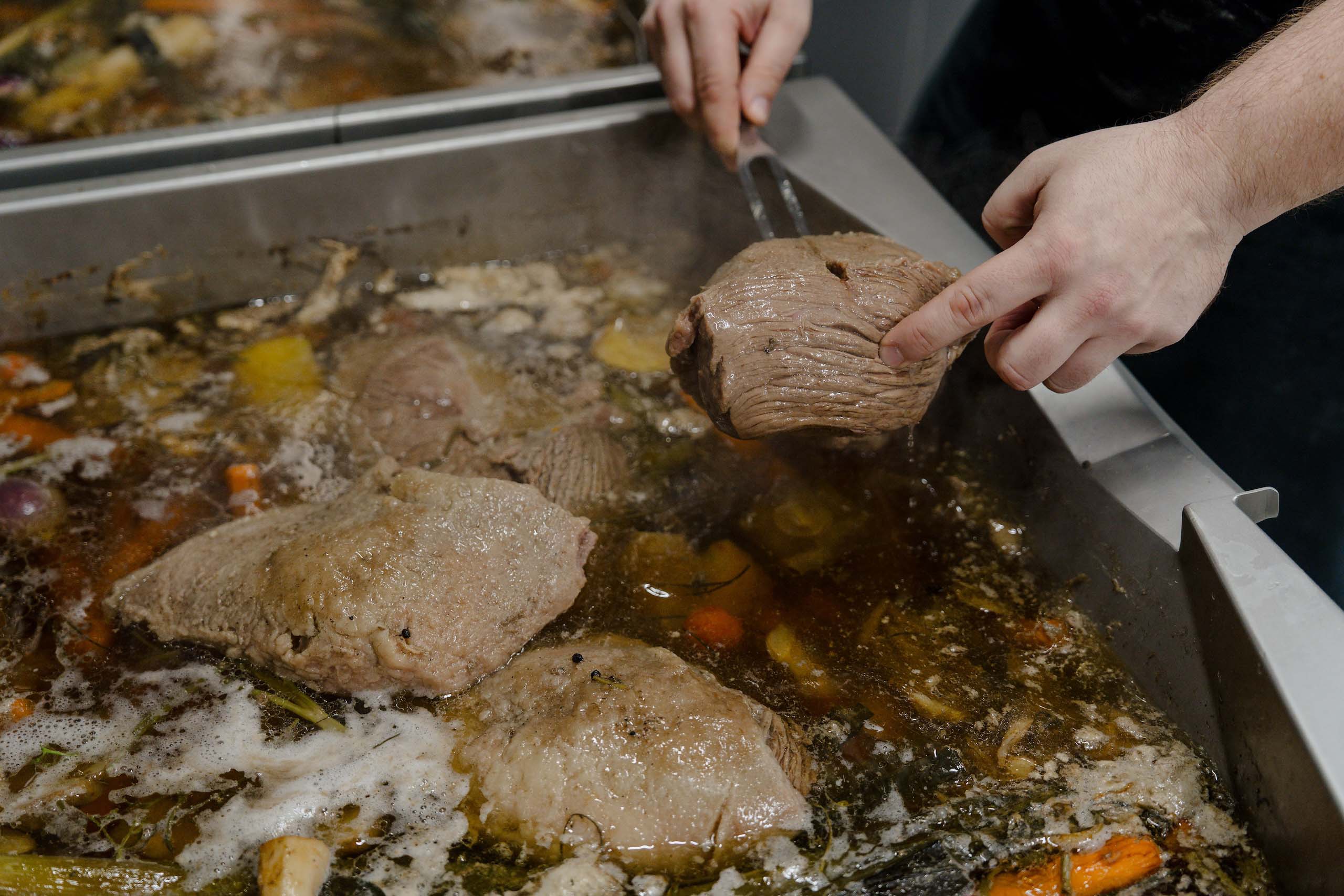 Frisch zubereitetes Hochzeitsessen: Saftige Fleischstücke in aromatischer Brühe als Teil eines unvergesslichen Hochzeitstraums.