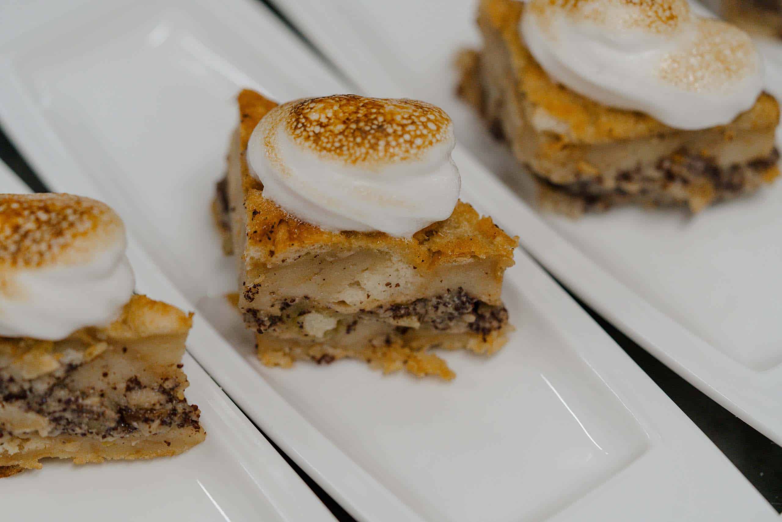 Hausgemachte Hochzeitstorte mit karamellisiertem Topping, elegant serviert auf weißem Geschirr, ideal für Hochzeitsfeiern.