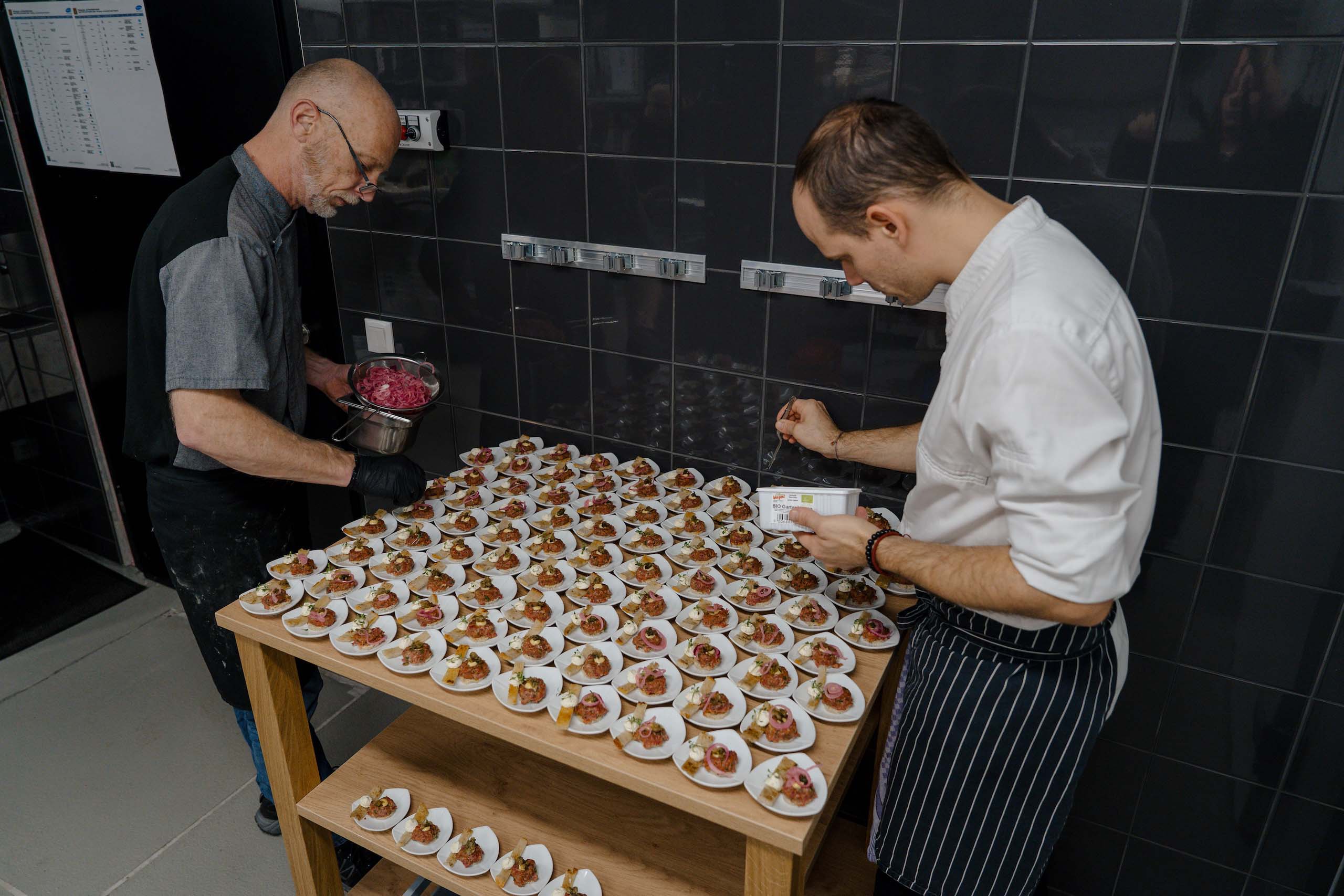Köche bereiten kunstvolle Canapés für eine Hochzeit vor, perfekt für unvergessliche Feiern in einer Traumhochzeitslocation.
