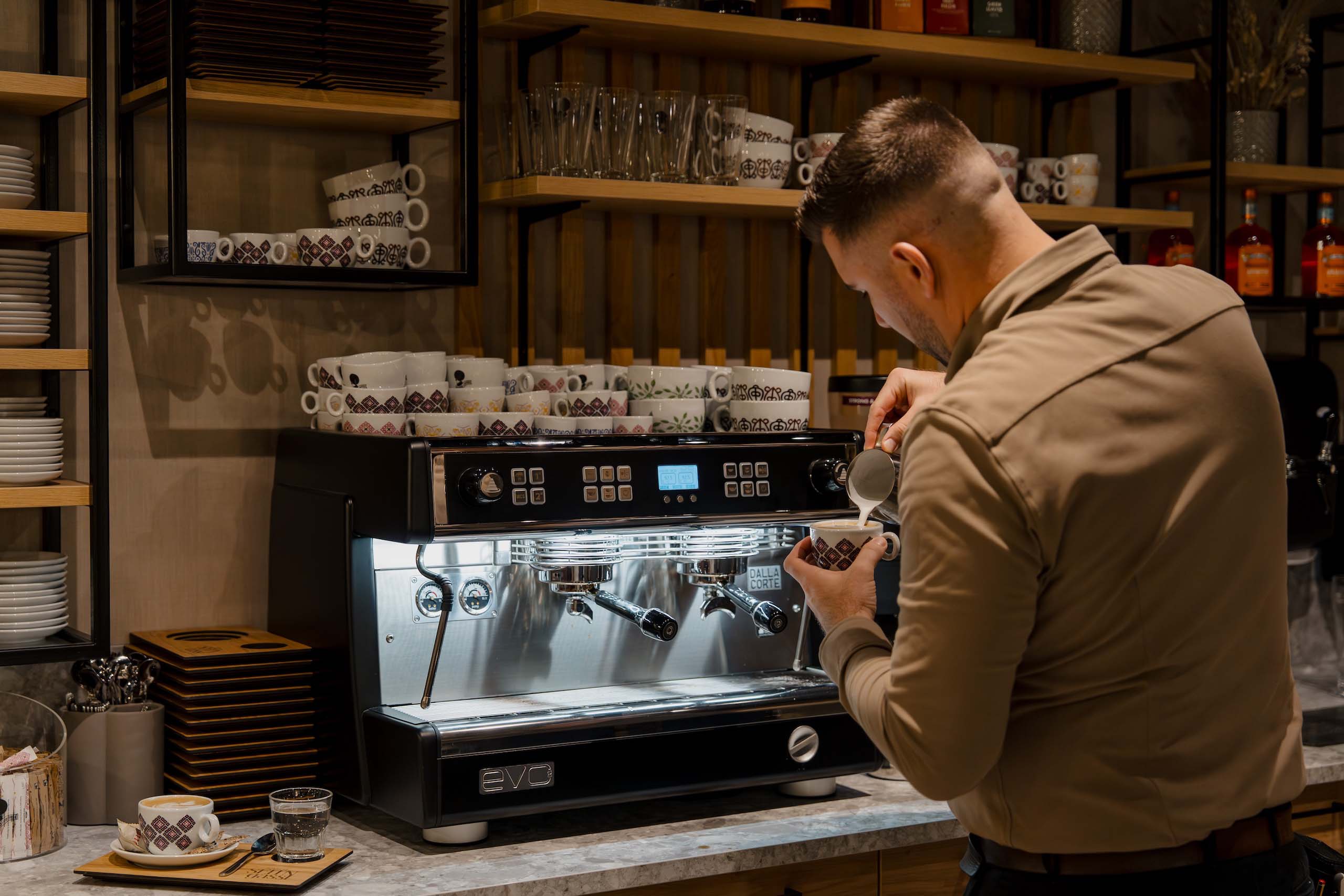 Barista bereitet Kaffee an der Espressomaschine in stilvoller Hochzeitslocation vor, perfektes Ambiente für Hochzeitsträume.