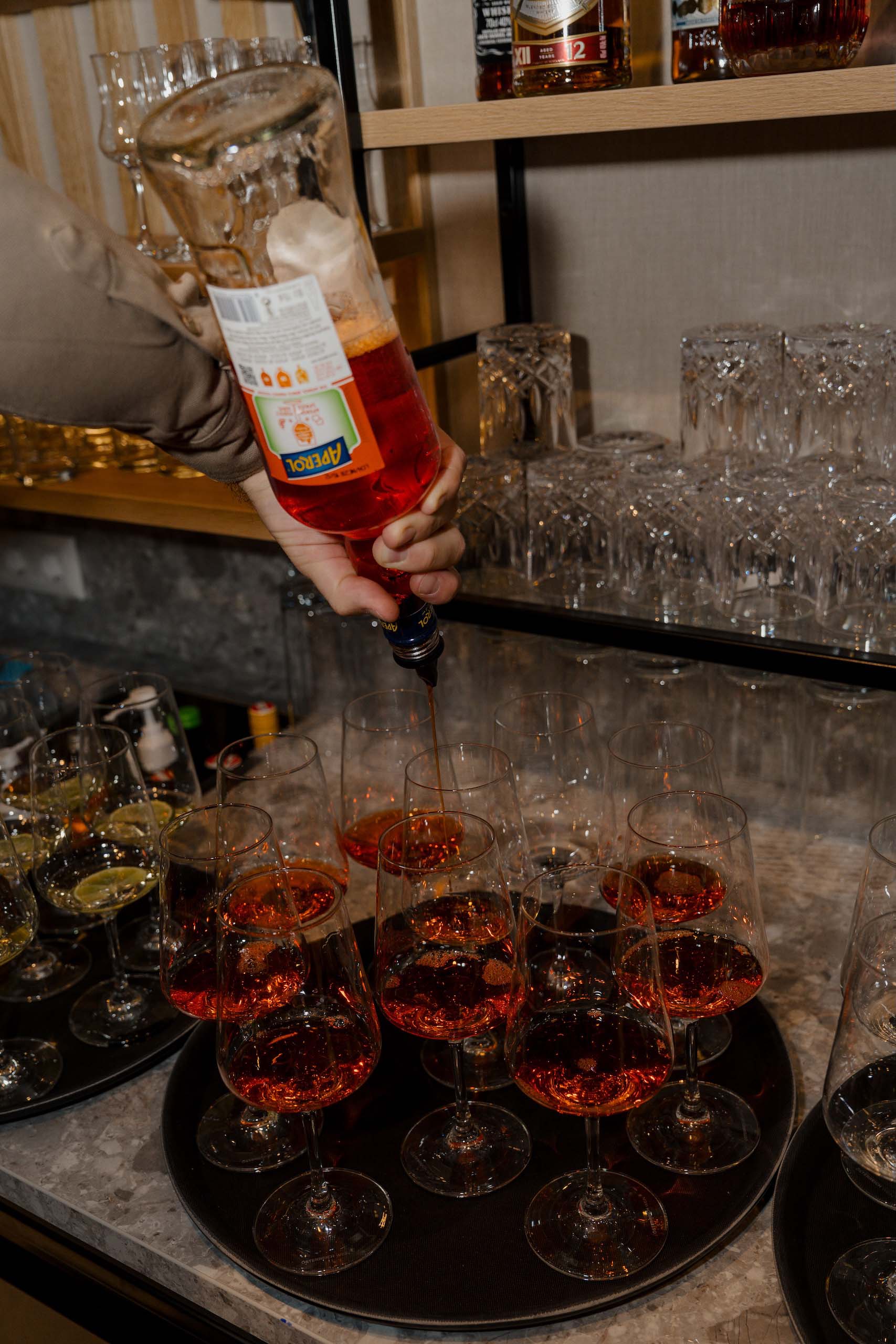 Getränke werden bei Hochzeitsfeier eingeschenkt, elegante Gläser in festlicher Location, passend zum Hochzeitstraum.