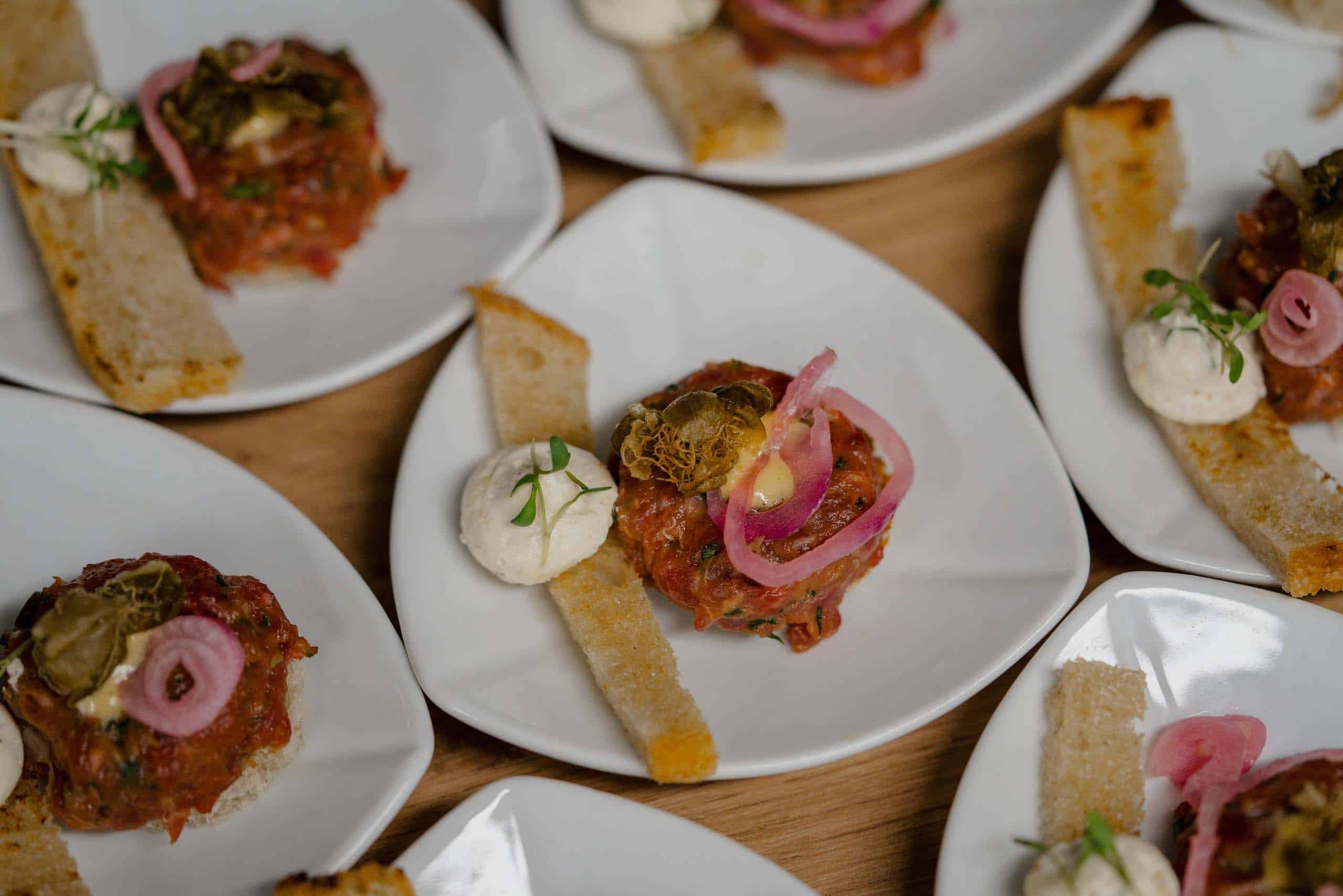 Gourmet-Vorspeisen mit Tatar und Crostini, serviert bei einer eleganten Hochzeit, ideal für gehobene Hochzeitslocations.