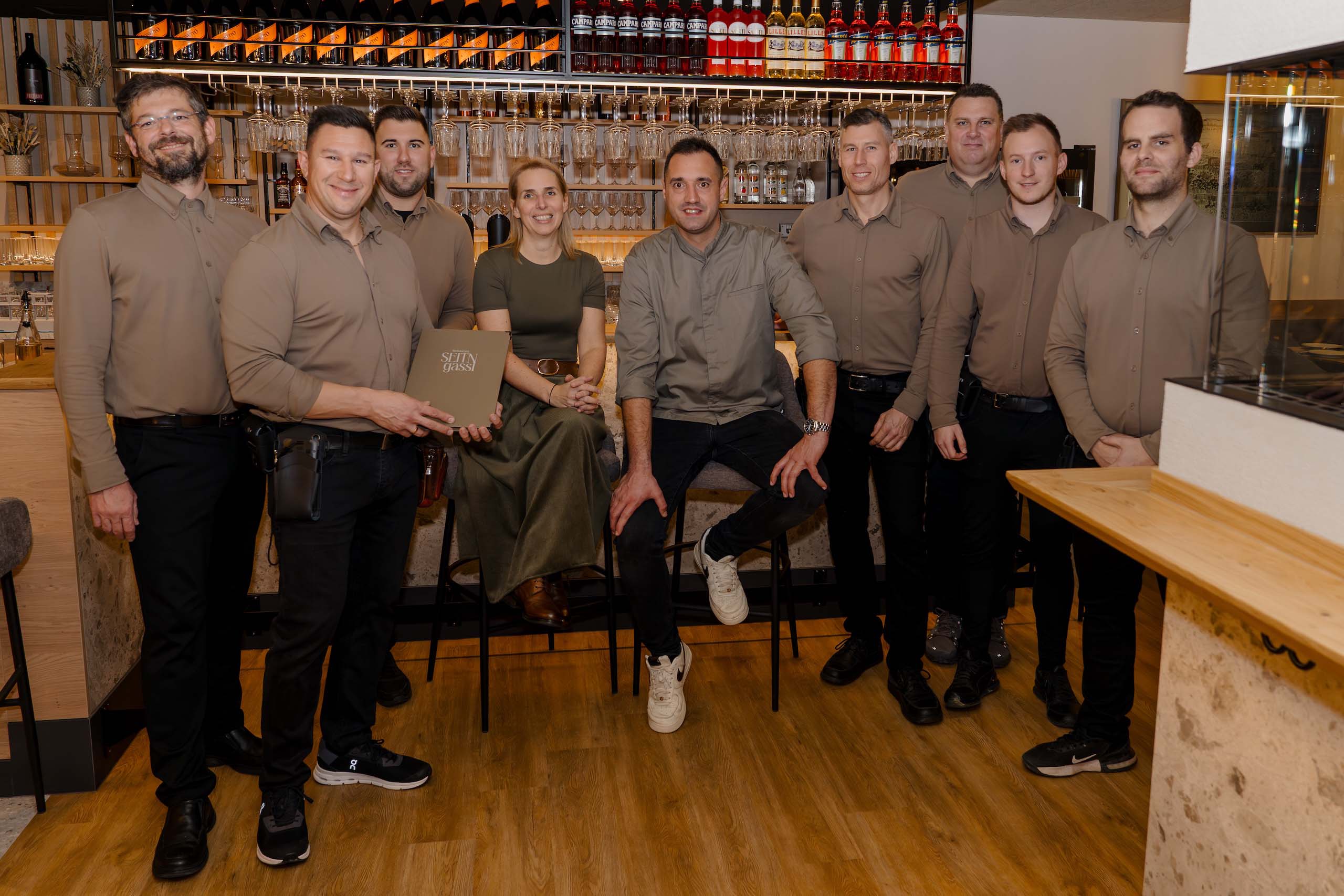 Team in eleganter Hochzeitslocation vor Bar, perfekt für Hochzeitsträume und Feiern. Ideal für Hochzeitsplanung und Events.