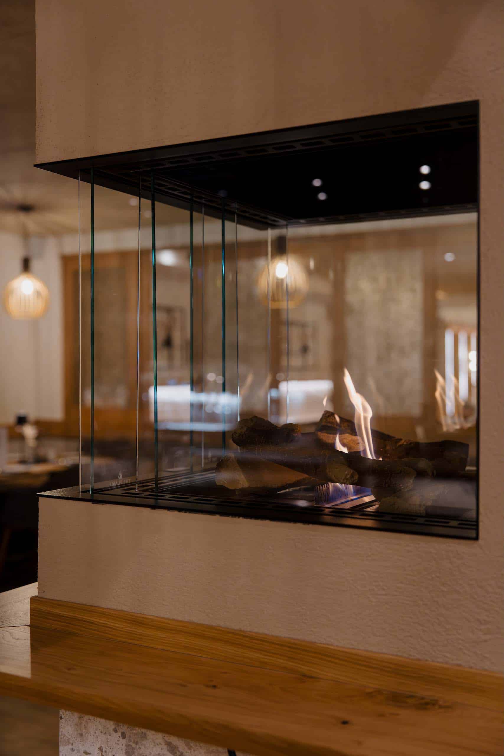 Gemütliches Kaminfeuer in eleganter Hochzeitslocation, ideal für romantische Feiern und unvergessliche Hochzeitsträume.