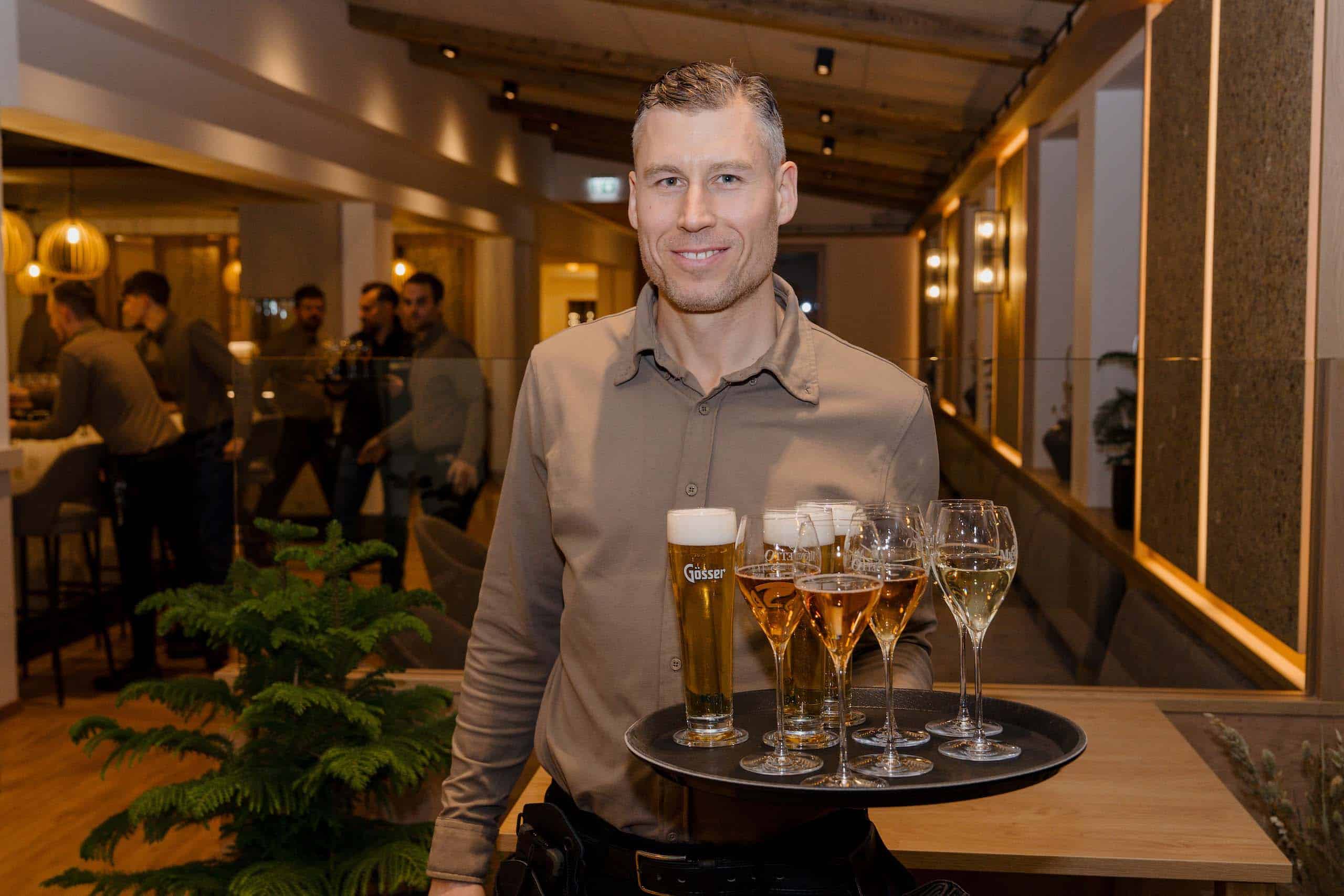 Kellner serviert Getränke in eleganter Hochzeitslocation, ideale Atmosphäre für unvergessliche Hochzeitsmomente.