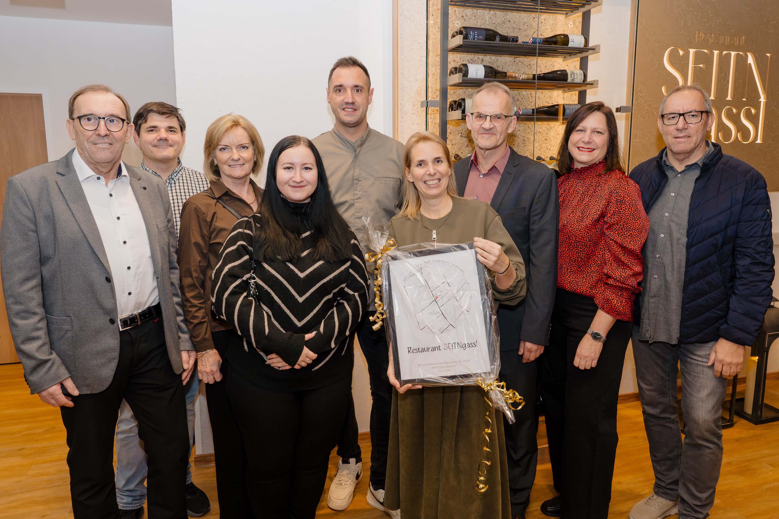 Eine Gruppe von Menschen posiert lächelnd in einem eleganten Restaurant, ideal für Hochzeitsfeiern und Events.