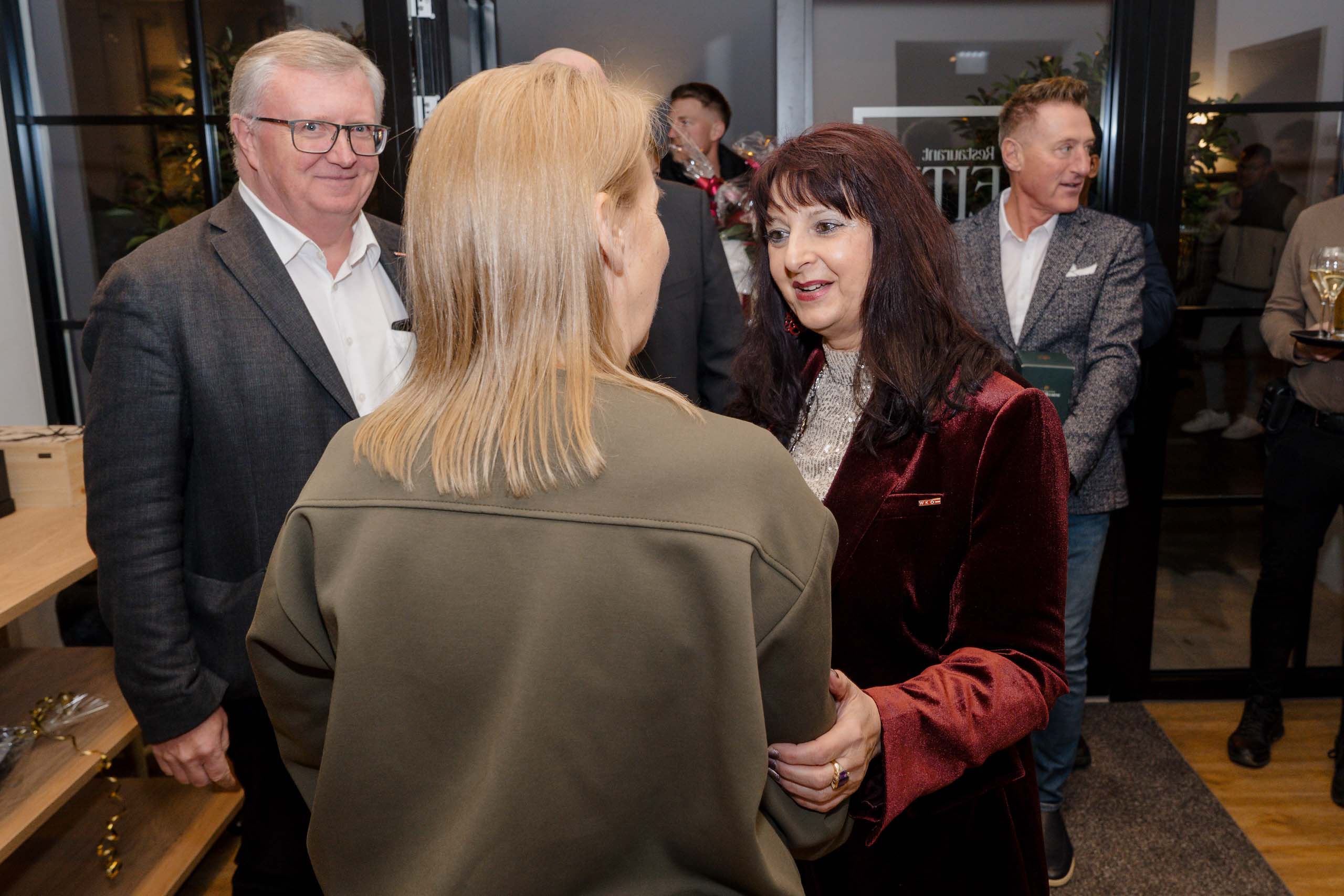 Menschen in feierlicher Kleidung tauschen sich in einer eleganten Hochzeitslocation aus. Elegante Atmosphäre bei einer Hochzeit.