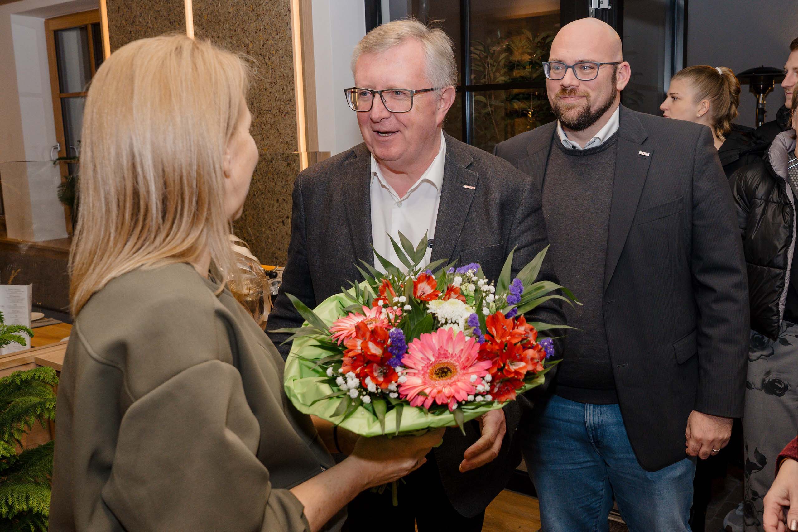 Ein Mann überreicht einer Frau einen lebhaften Blumenstrauß, ideal für eine Hochzeitslocation oder -feier.