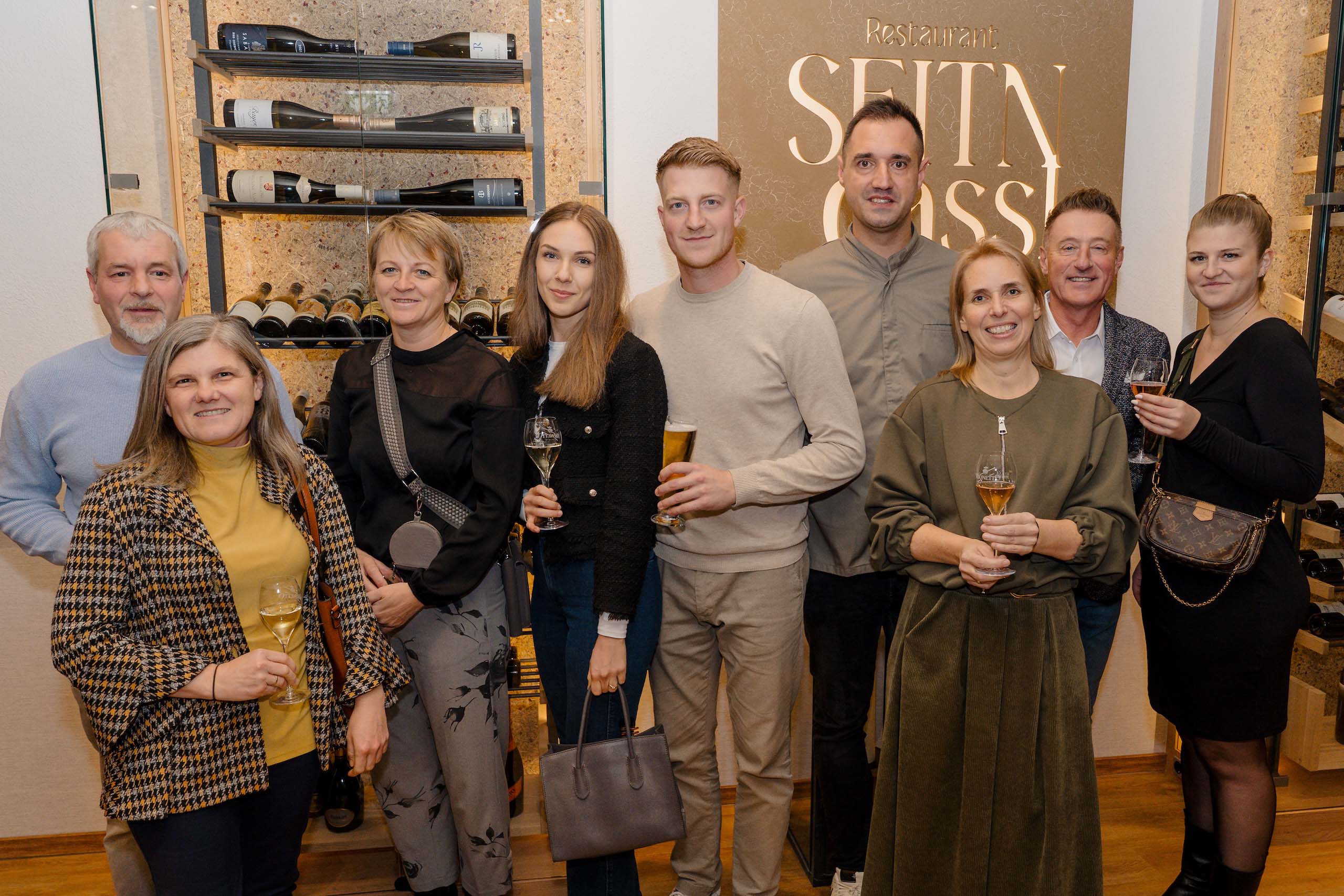 Gäste halten Getränke in stilvoller Hochzeitslocation mit Weindekor, ideale Atmosphäre für den Hochzeitstraum.