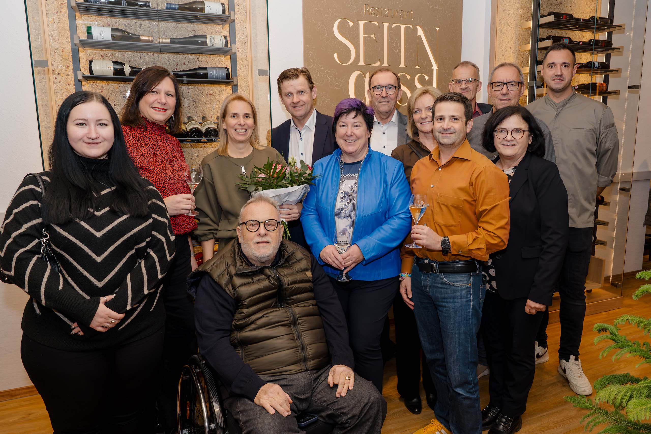 Eine Gruppe fröhlicher Menschen bei einer Feier in einer stilvollen Hochzeitslocation, ideal für Hochzeitsträume.