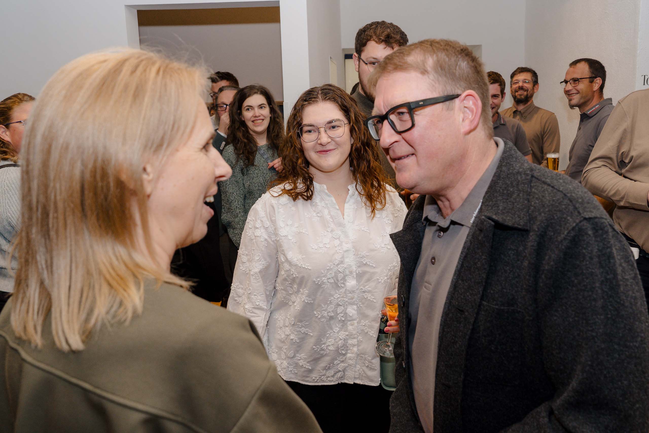 Menschen lächeln bei lockerer Unterhaltung während einer Hochzeit an einer einladenden Feier in einer schönen Location.