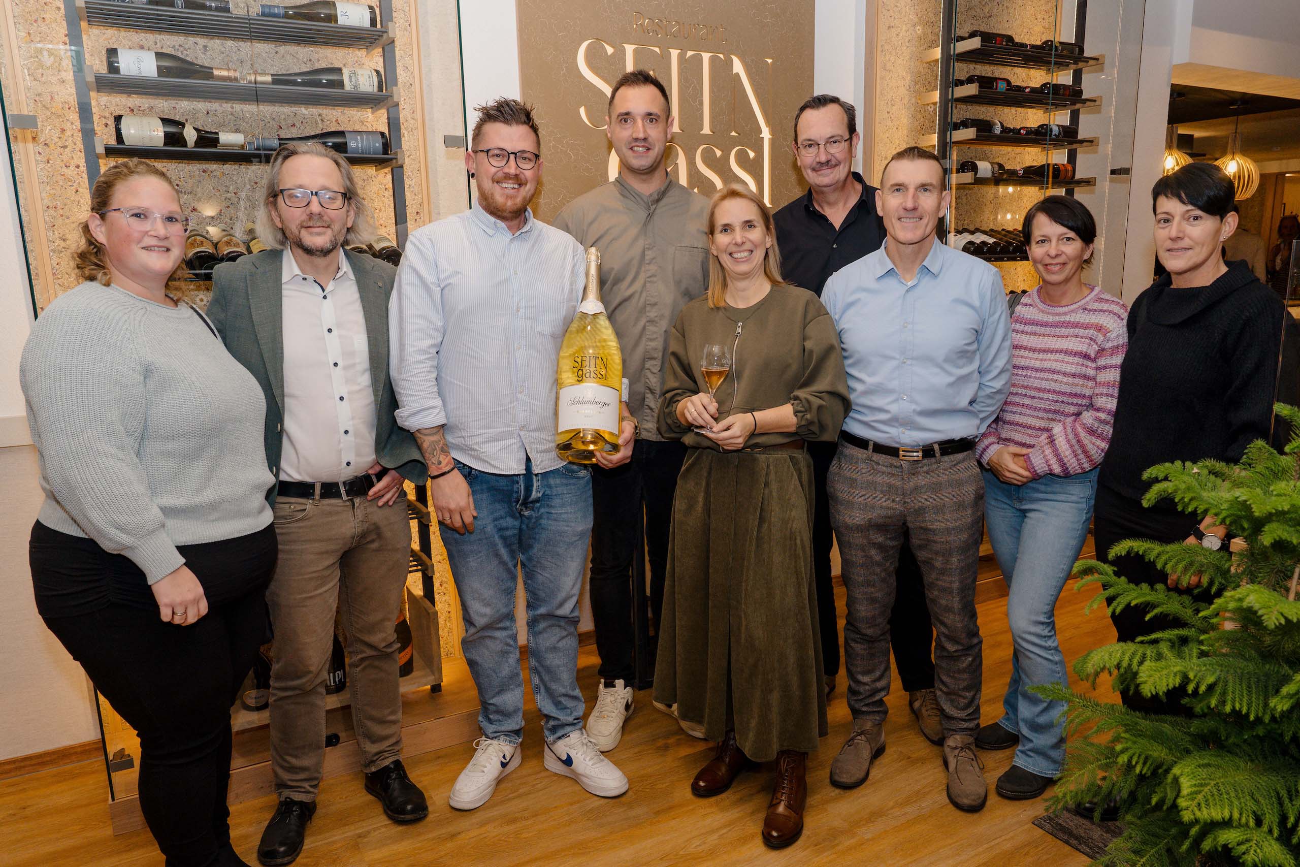 Gruppe fröhlicher Menschen bei einer Hochzeitsbesichtigung in einer stilvollen Weinbar, perfekt für Hochzeitsfeiern.