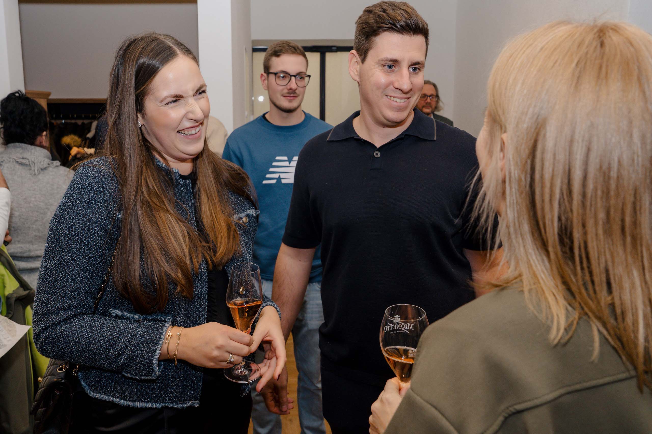 Geselliges Beisammensein bei einer Hochzeitslocation-Besichtigung, Gäste lachen und genießen Drinks.