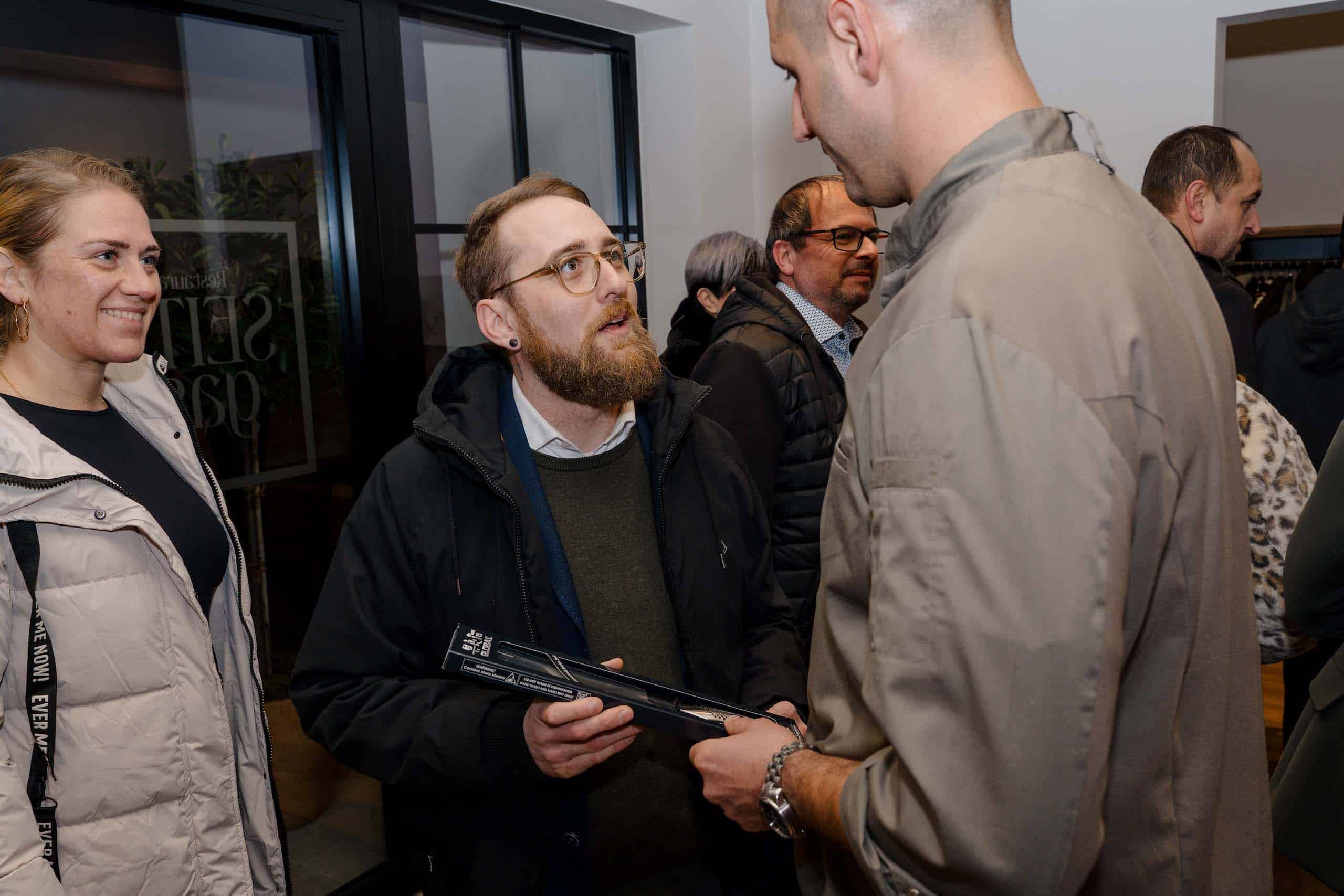 Gruppe von Menschen im Gespräch auf einer Hochzeitsmesse; mögliche Inspiration für die perfekte Hochzeitslocation.