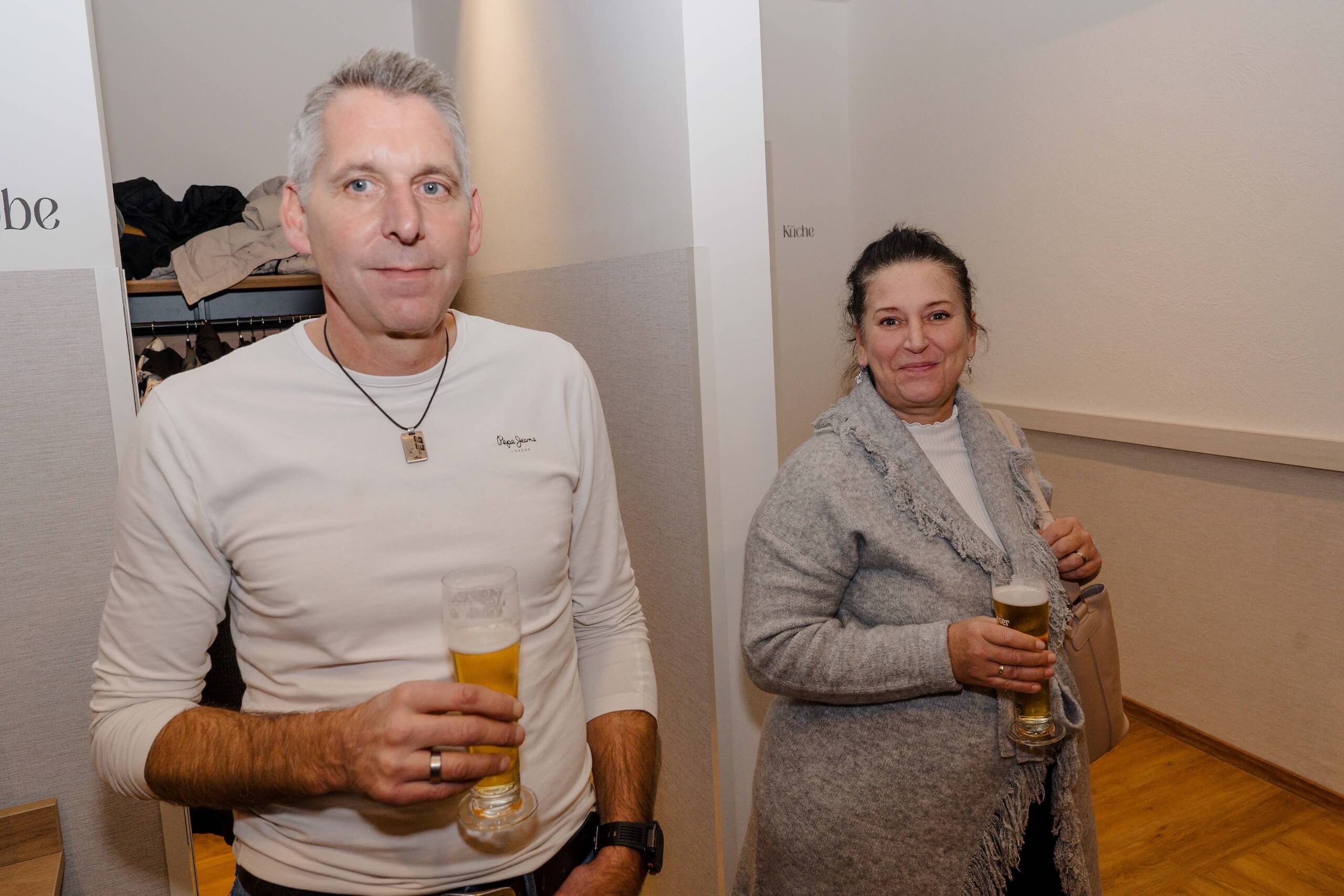 Paar bei Hochzeitsfeier hält Getränke, entspannt in stilvoller Location, symbolisiert gemeinsames Glück und Feierfreude.