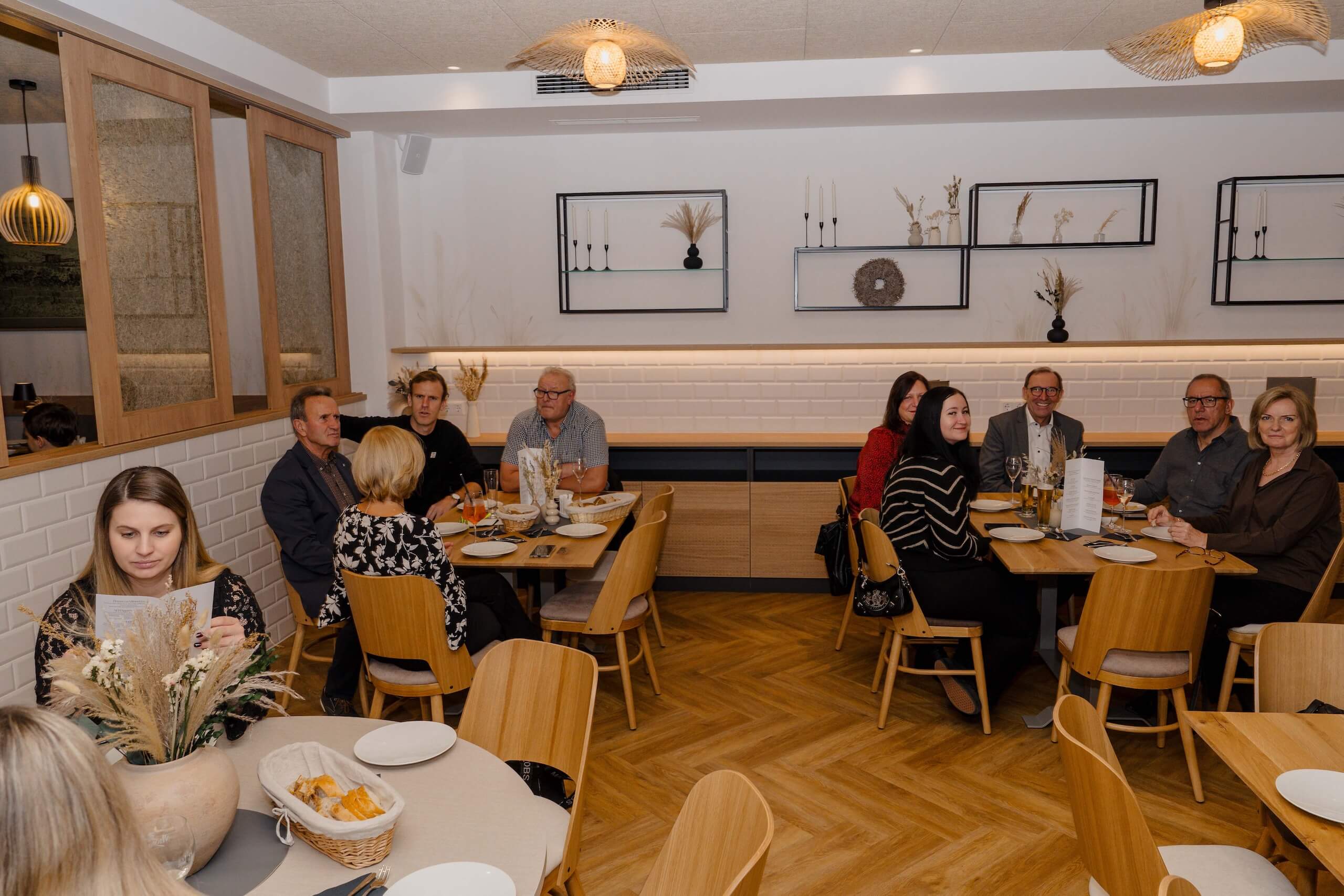 Gäste sitzen in eleganter Hochzeitlocation, genießen festliches Ambiente und Dekoration im Hochzeitstraum-Restaurant.