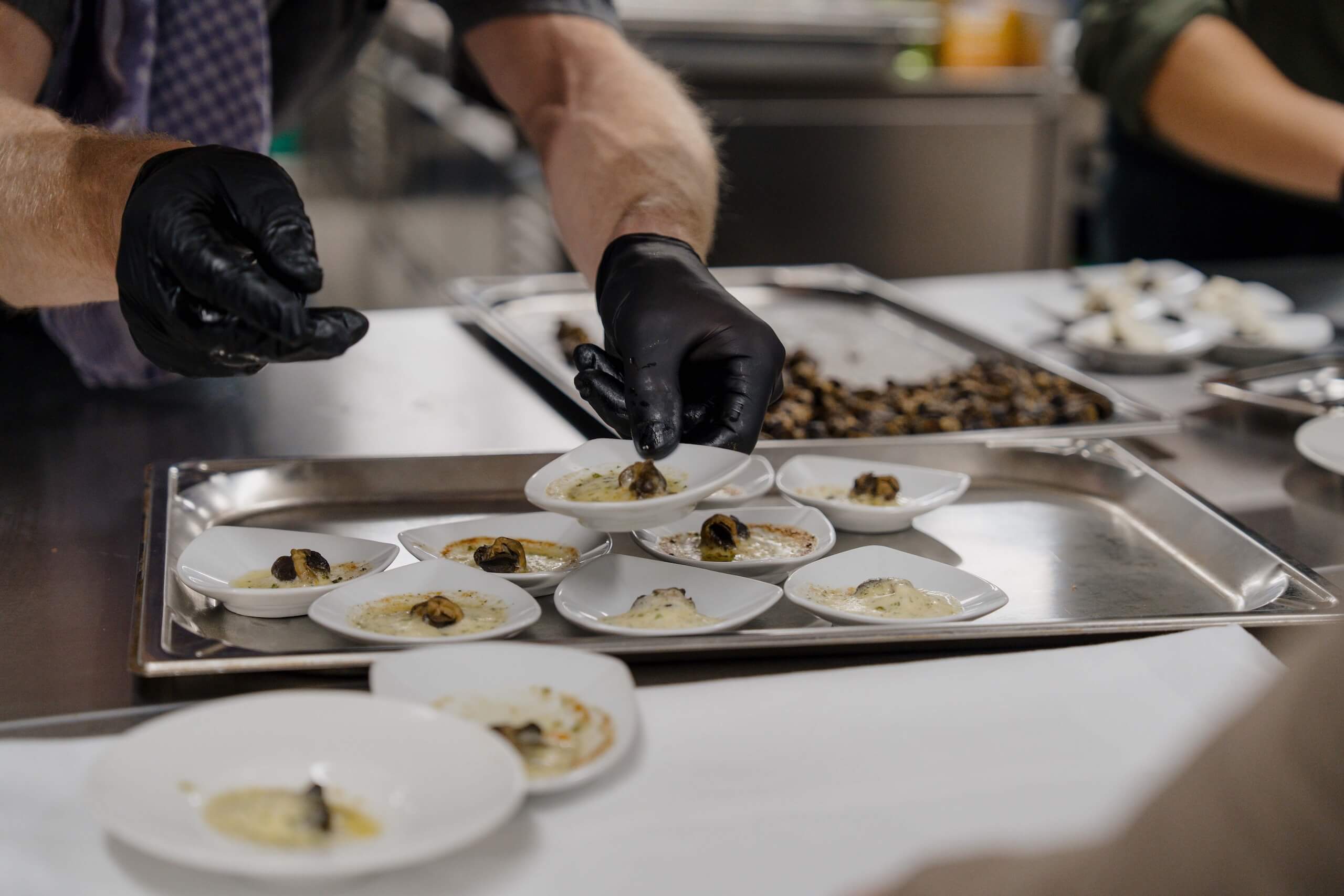 Koch arrangiert Gourmet-Vorspeisen für eine Hochzeit, perfekter Start für den Hochzeitstraum in eleganter Hochzeitslocation.