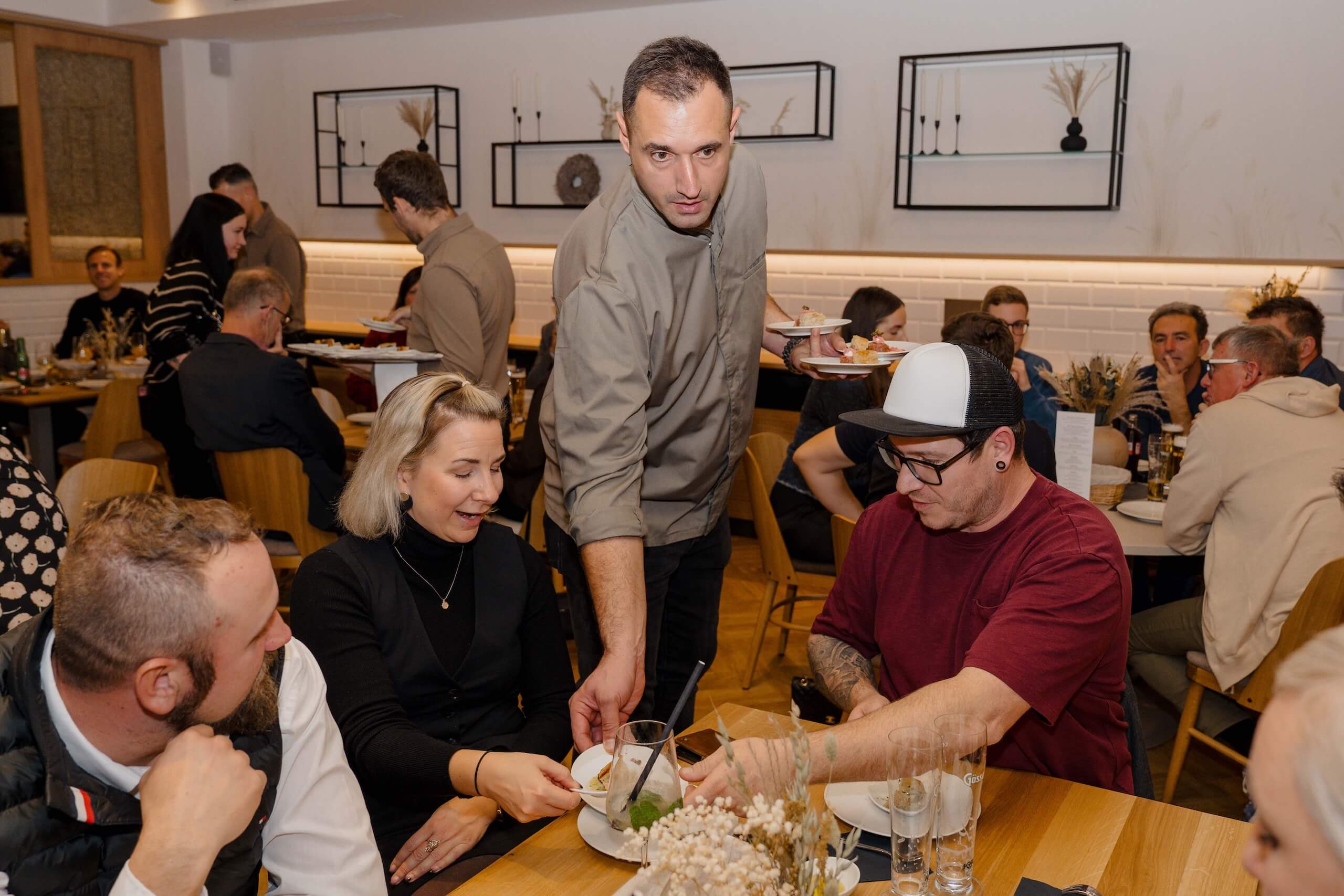 Eine Hochzeitsgesellschaft genießt ein festliches Dinner in einer elegant dekorierten Hochzeitslocation.