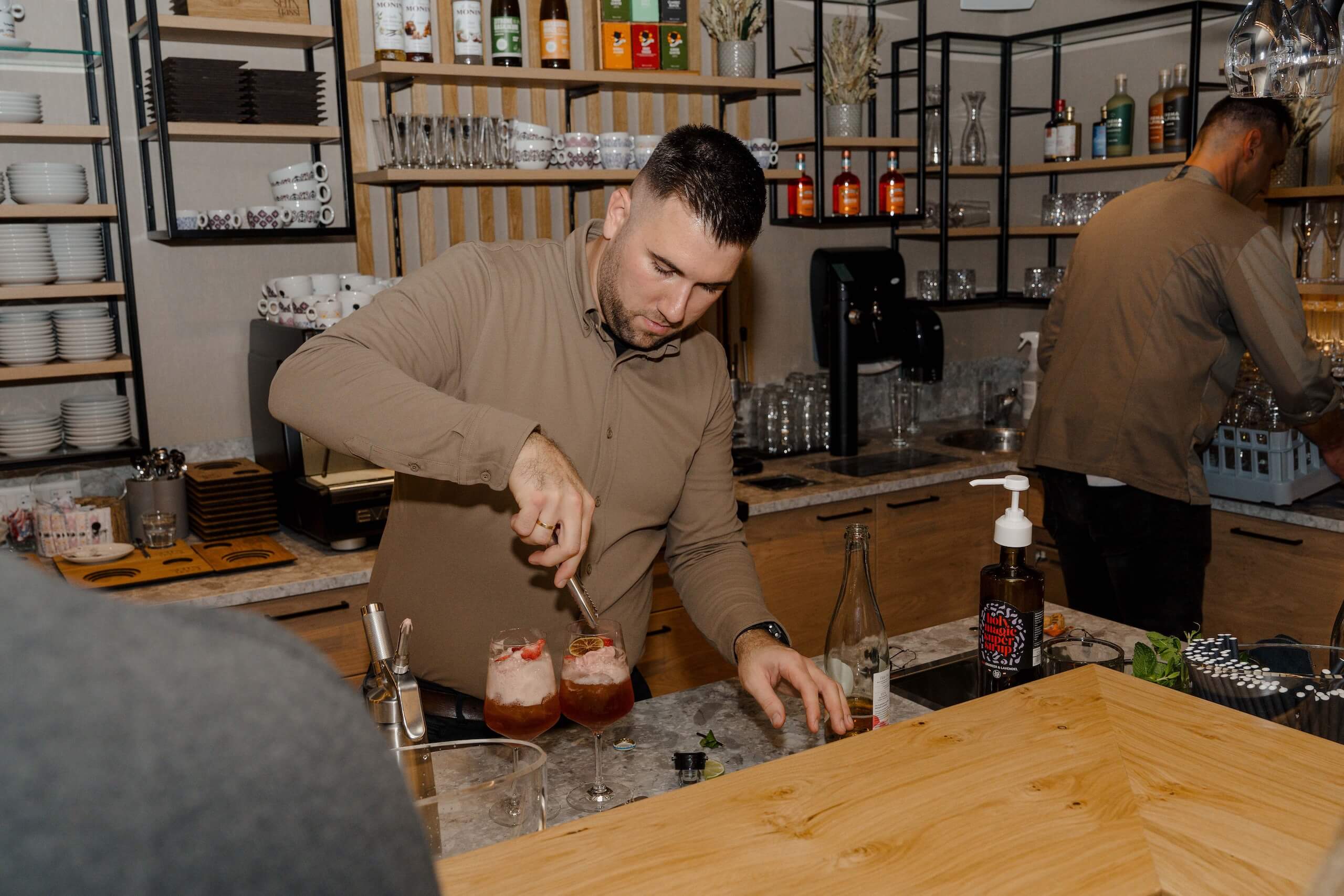 Barkeeper mixt Cocktails an eleganter Bar, ideal für unvergessliche Hochzeiten in stilvoller Hochzeitslocation.