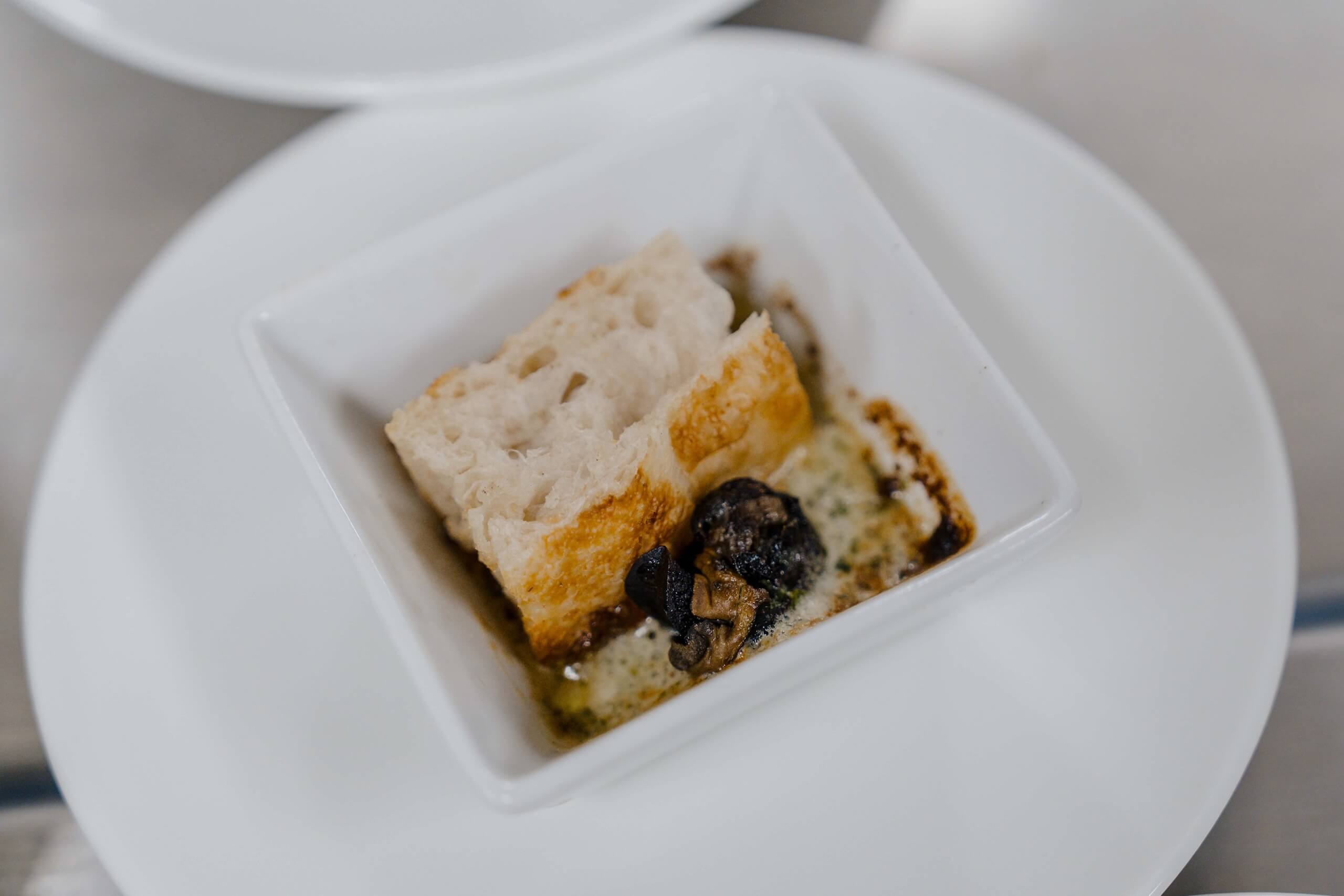 Vorspeise bei Hochzeitsfeier: Brot und Pilze in cremiger Sauce in weißem Schälchen, Hochzeitstraum Kulinarik.