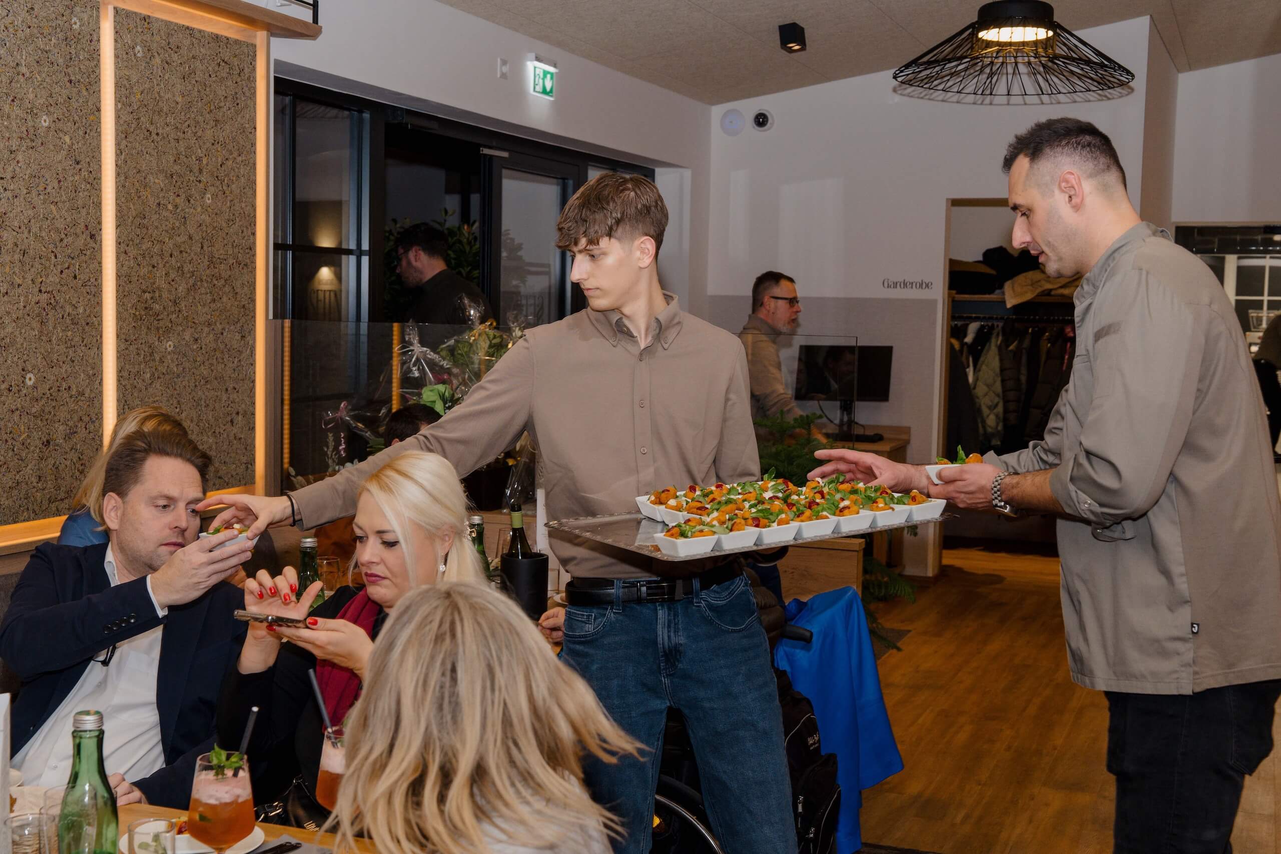 Gäste genießen elegante Appetithäppchen bei einer stilvollen Hochzeit in einer modernen Eventlocation.