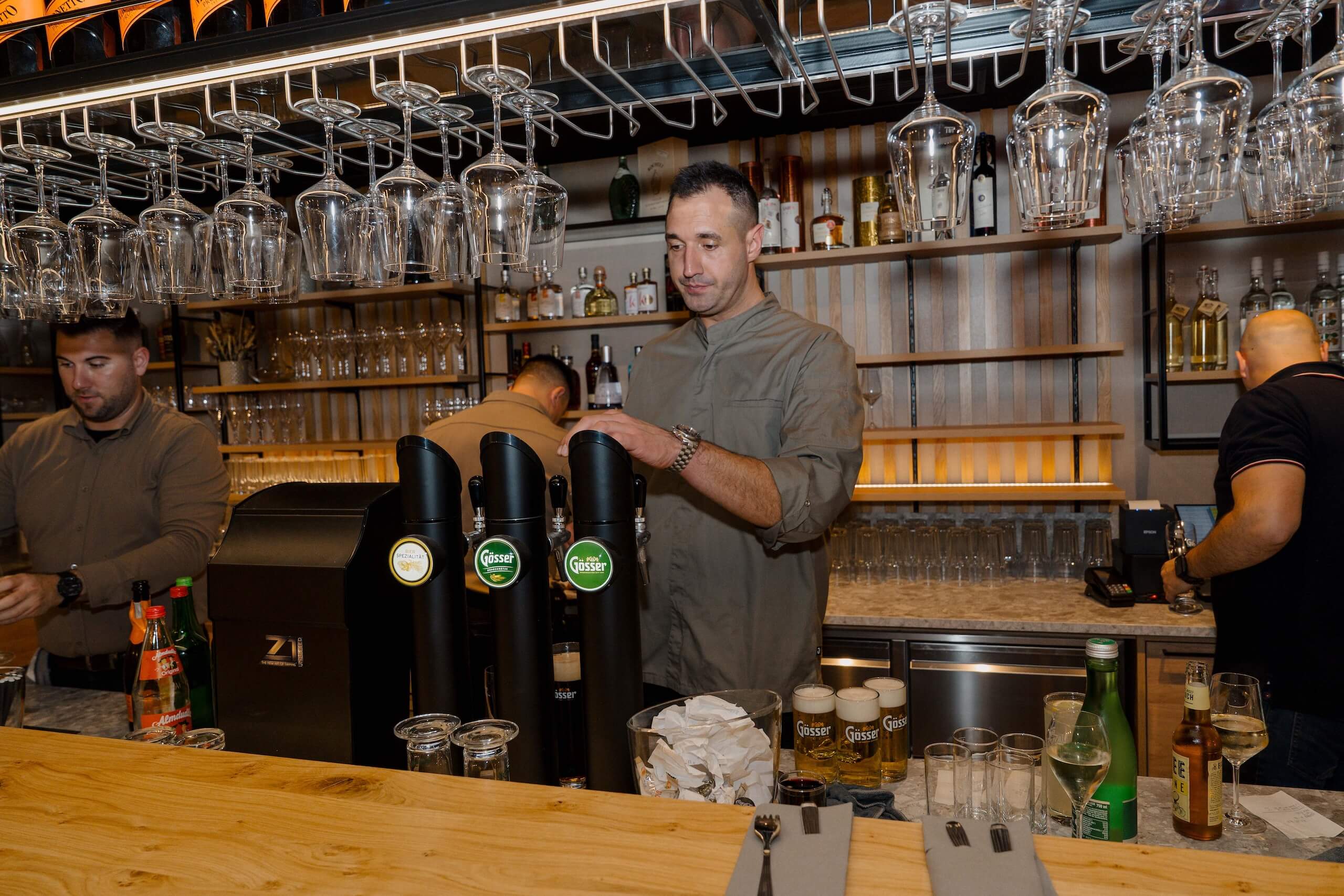 Barkeeper servieren Getränke an stilvoller Bar bei Hochzeitslocation, perfekt für Hochzeitstraum-Erlebnisse.