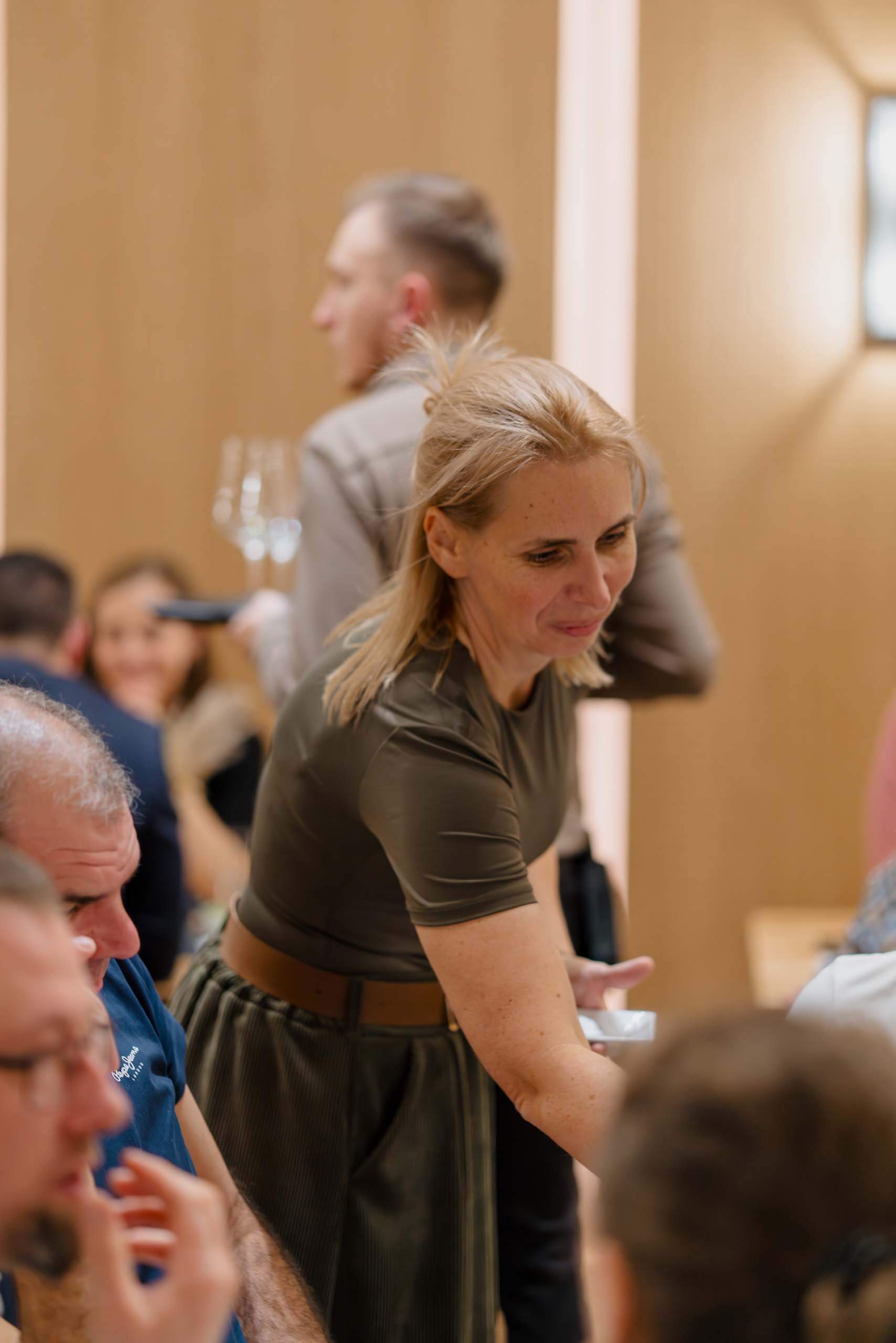 Gäste genießen lächelnd ein freundliches Hochzeitsessen in einer eleganten Hochzeitslocation.