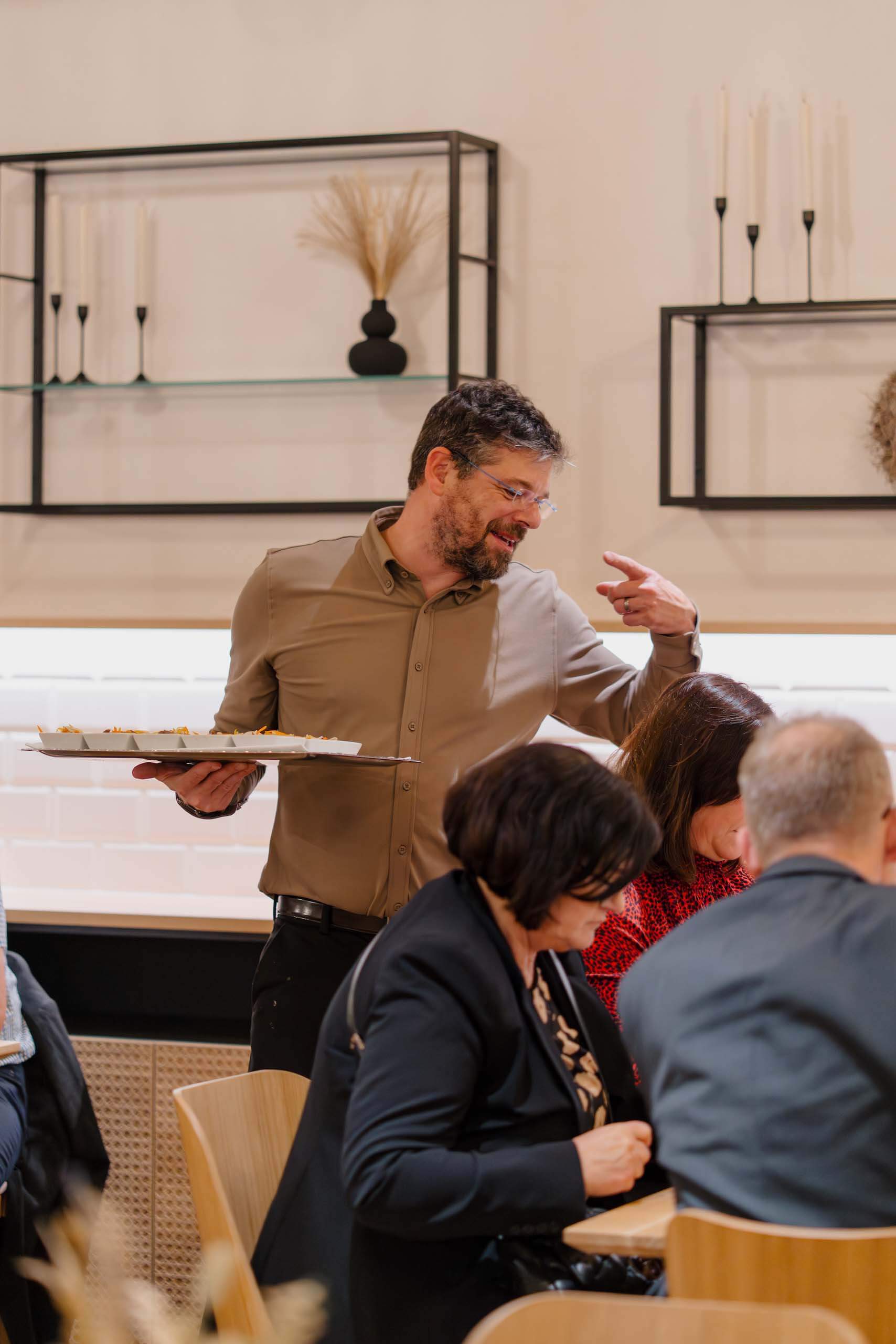 Gastgeber serviert Speisen bei eleganter Hochzeit in stilvoll dekorierter Location.