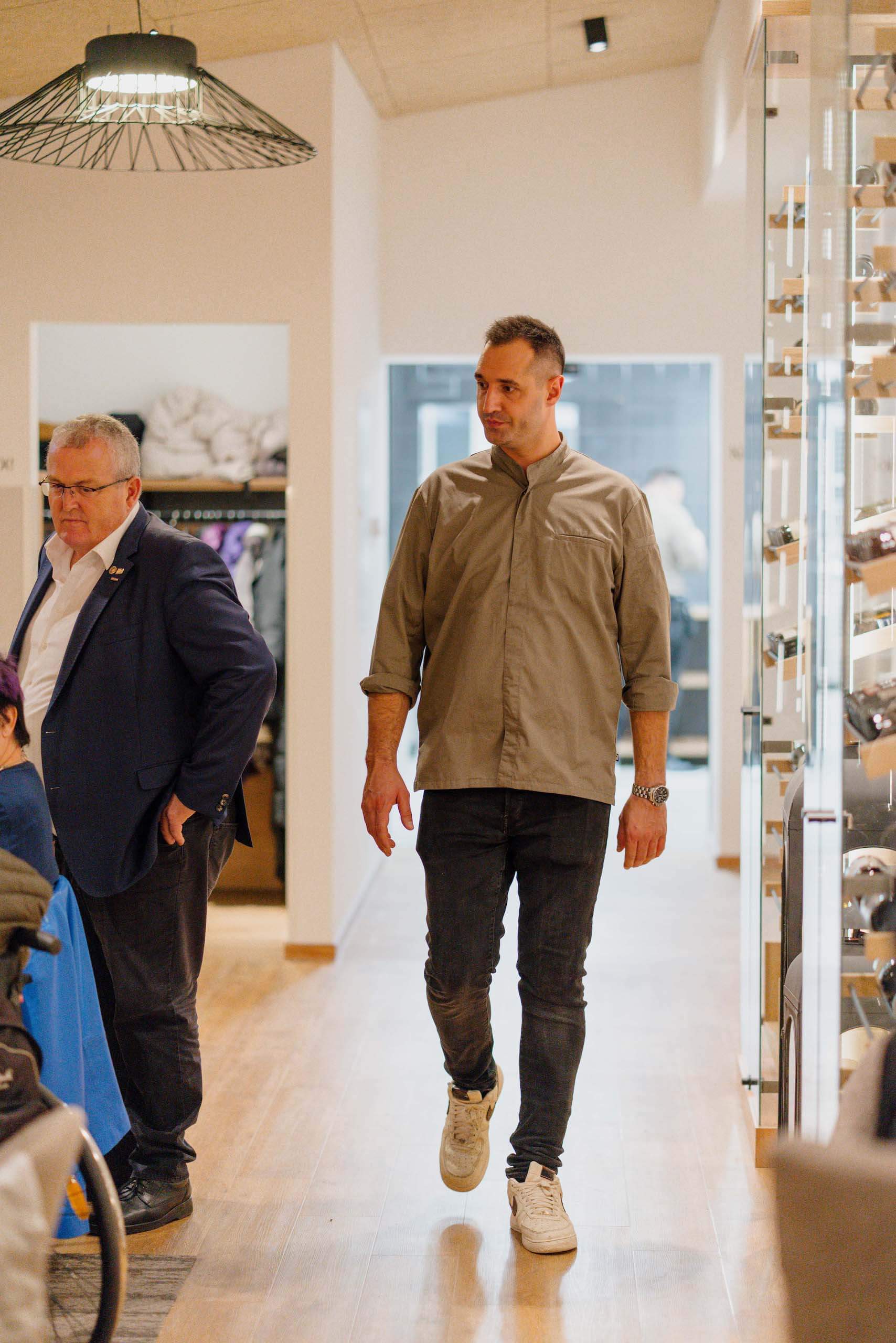 Zwei Männer in einer eleganten Hochzeitslocation, warme Beleuchtung, Holzfußboden, stilvoll für Hochzeitsträume geeignet.